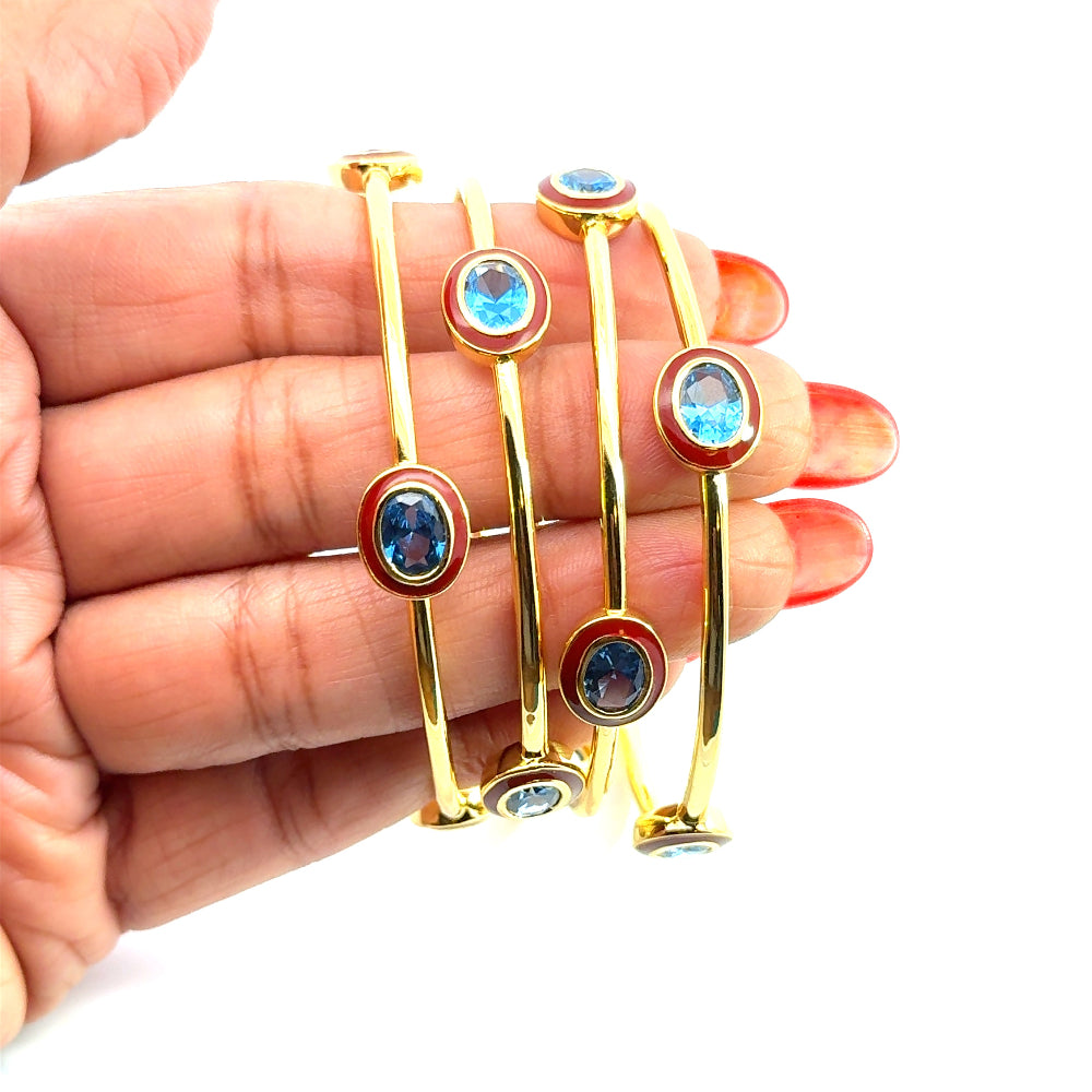 Bohemian 22K gold plated bangle with sparkling oval created Spinel and red enamel detailing. Perfect for stacking or statement styling. Shop premium jewelry online.