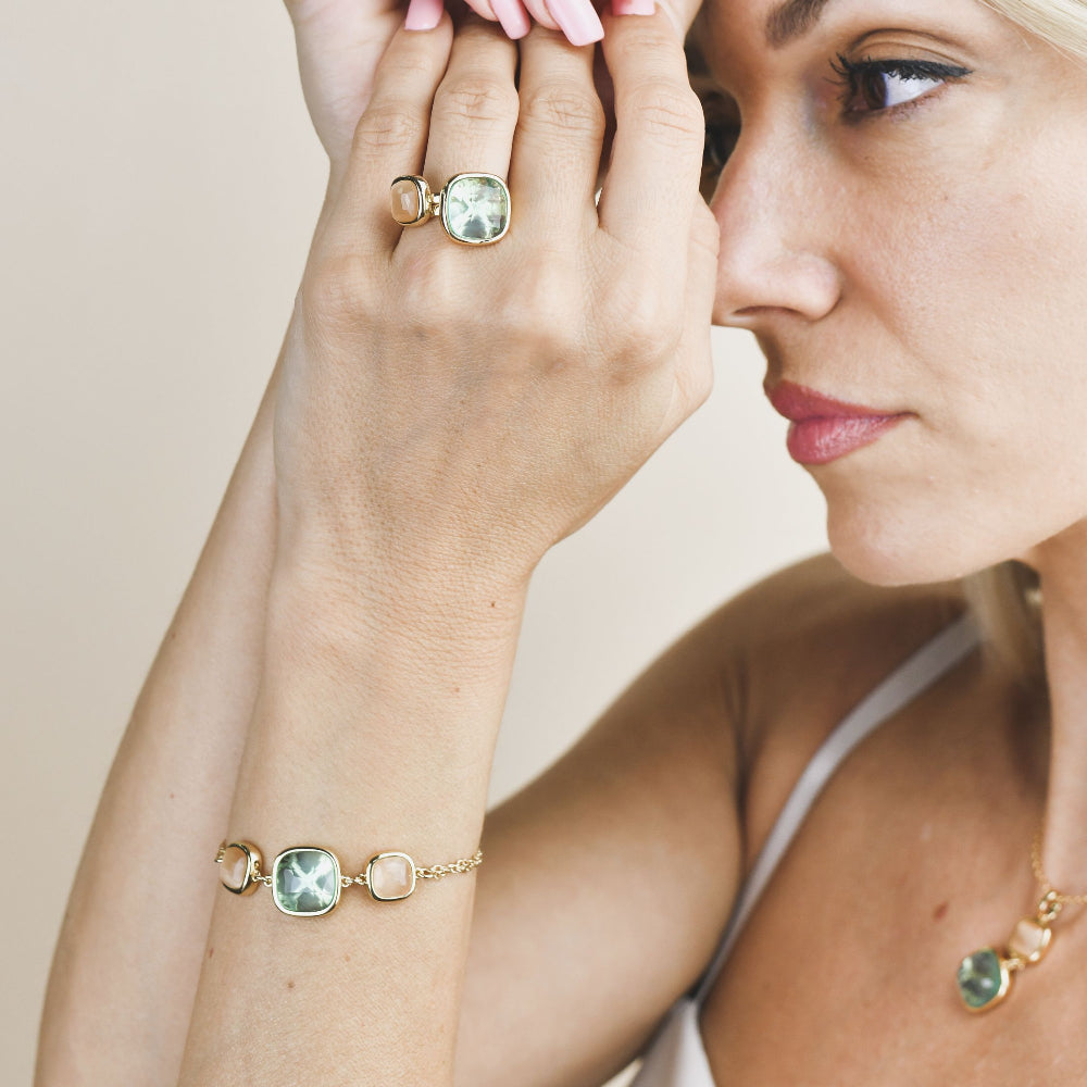 Yellow gold plated bracelet with a striking aquamarine crystal and peach-toned crystal accents for a stylish modern touch. Shop premium jewelry online.