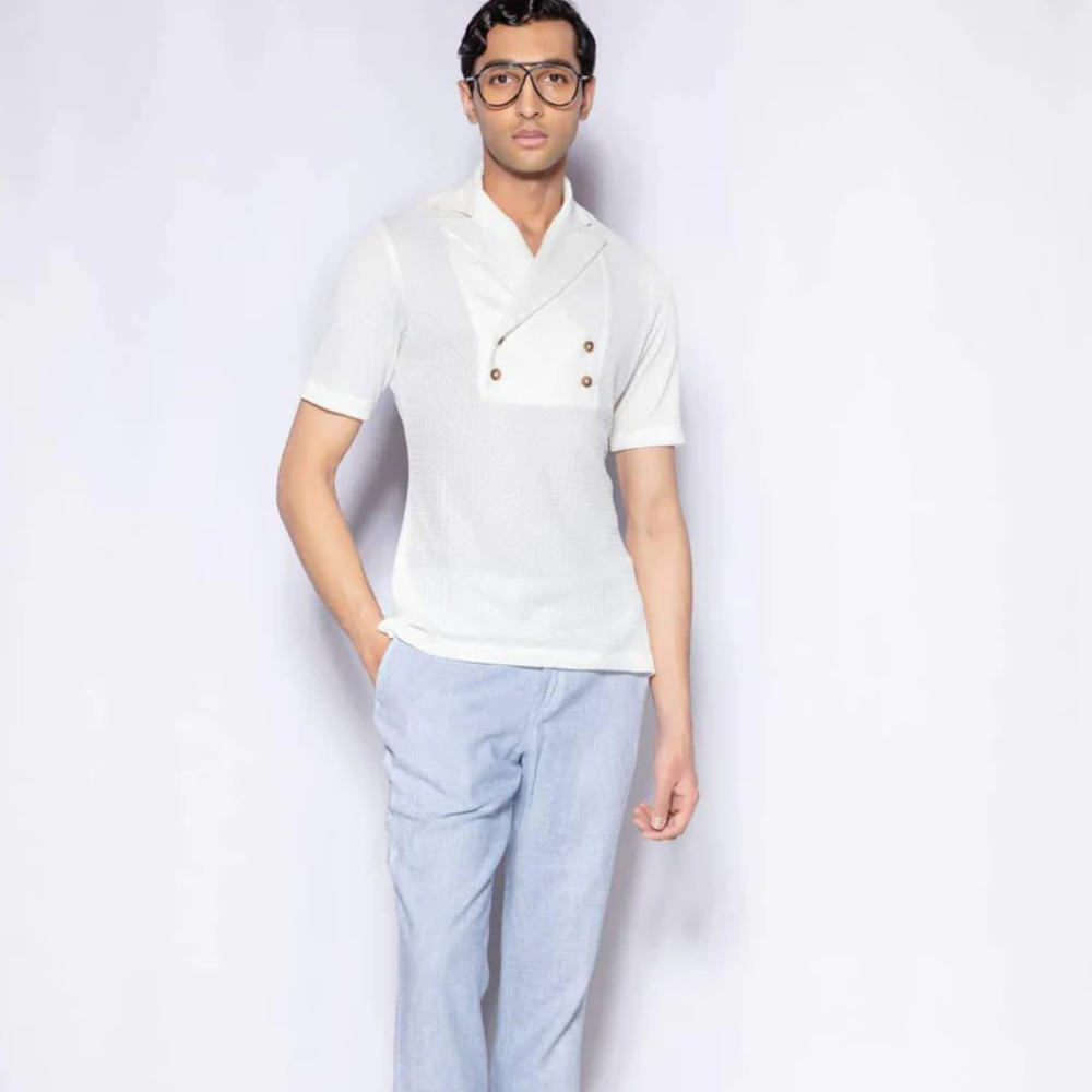 Napeta close collar neck with ruffles around and full sleeves. The bodice is paired with white ciggerate high waist pant.