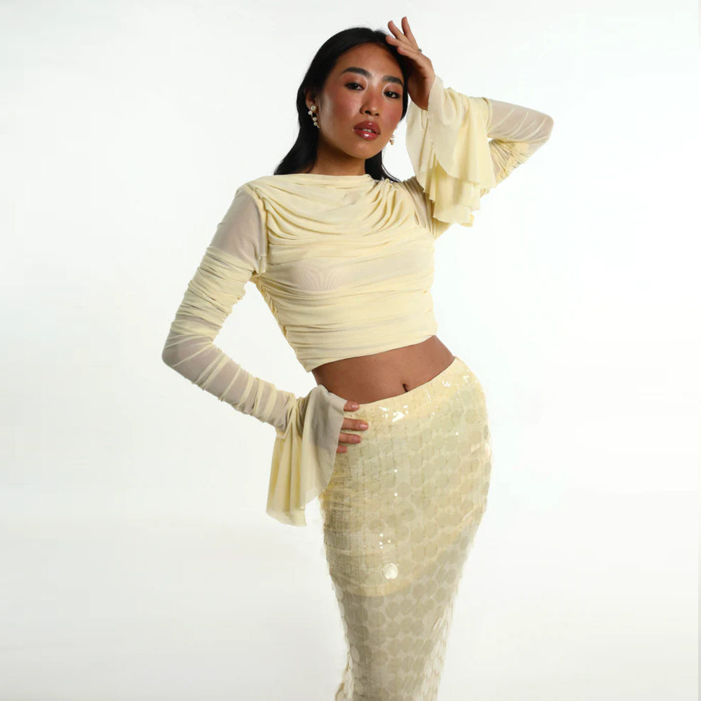 Pastel yellow set with ruched mesh top and sequin skirt, perfect for parties. Shop online from our curated edit of premium fashion.