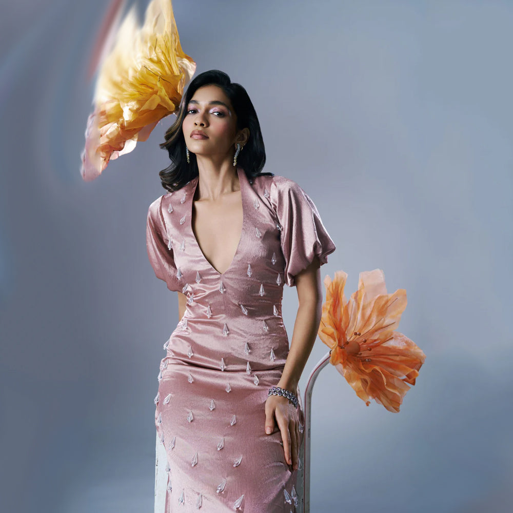 Peach satin maxi dress with V-neck, puff sleeves and crystal tassels, perfect for events. Shop online from our exclusive collection of premium styles.