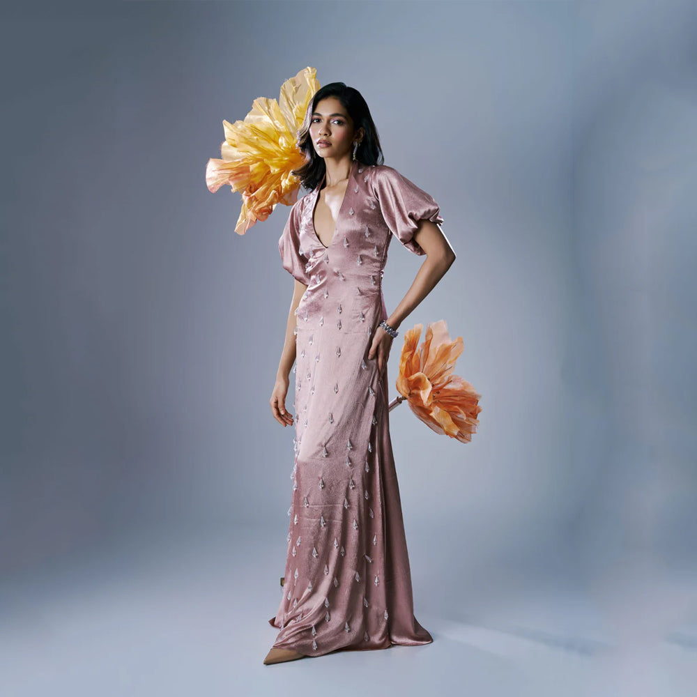 Peach satin maxi dress with V-neck, puff sleeves and crystal tassels, perfect for events. Shop online from our exclusive collection of premium styles.