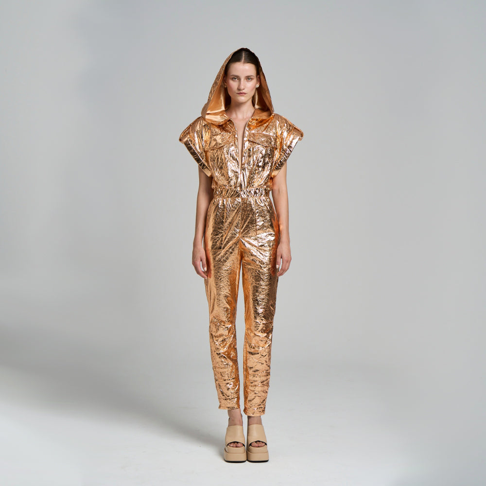 Short sleeve jumpsuit. .Gusseted pocket .Elastic waist .Hoodie .Shiny tyvek fabric .It can be washed, not ironed.