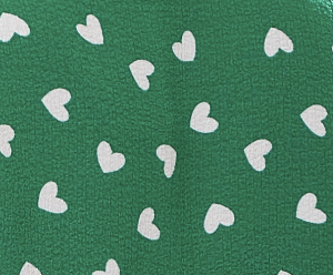 Women's White Heart Print Shirt in Green - Short sleeves, oversized fit, heart-shaped buttons, button-up front, collar.