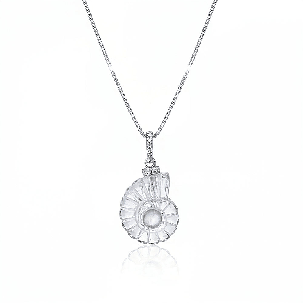 Discover the SeaDream Crystal & Moonstone Shell Pendant at The Luxe Maison, featuring a carved crystal shell, luminous moonstone center, and elegant ocean-inspired design.