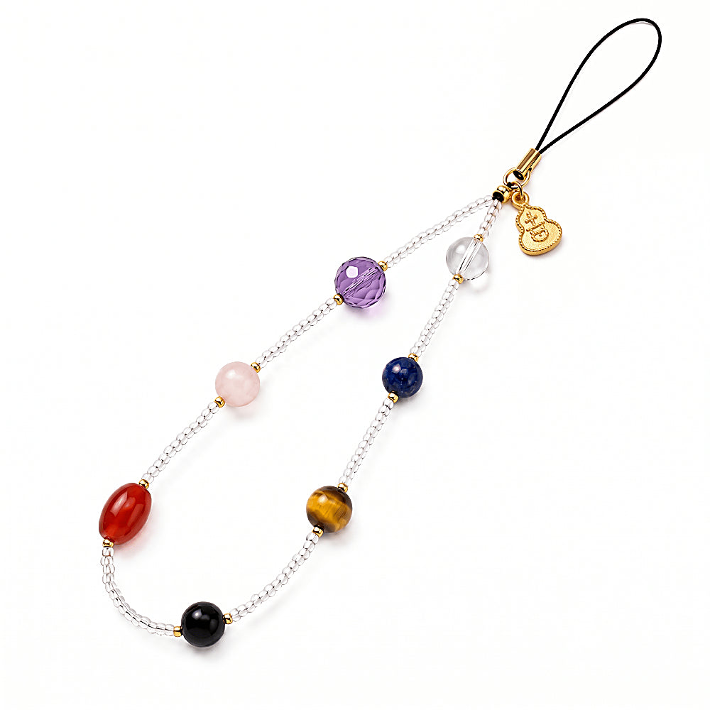 Discover the Seven Chakras Gemstone Phone Strap at The Luxe Maison, featuring natural crystals, golden accents, and a lucky charm for a colorful, celestial-inspired accessory.