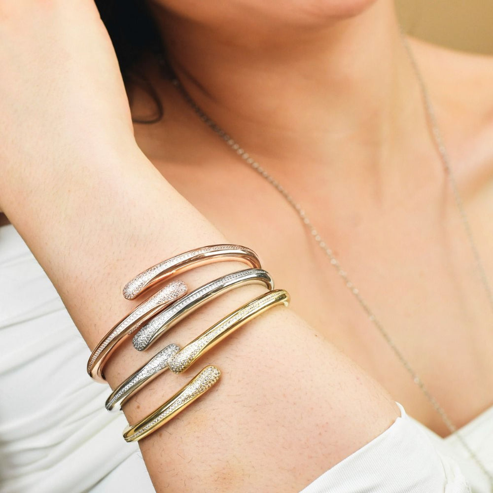 Elegant gold plated bronze wrap cuff bracelet adorned with sparkling pavé cubic zirconia stones for a timeless luxe look. Shop premium jewelry online.