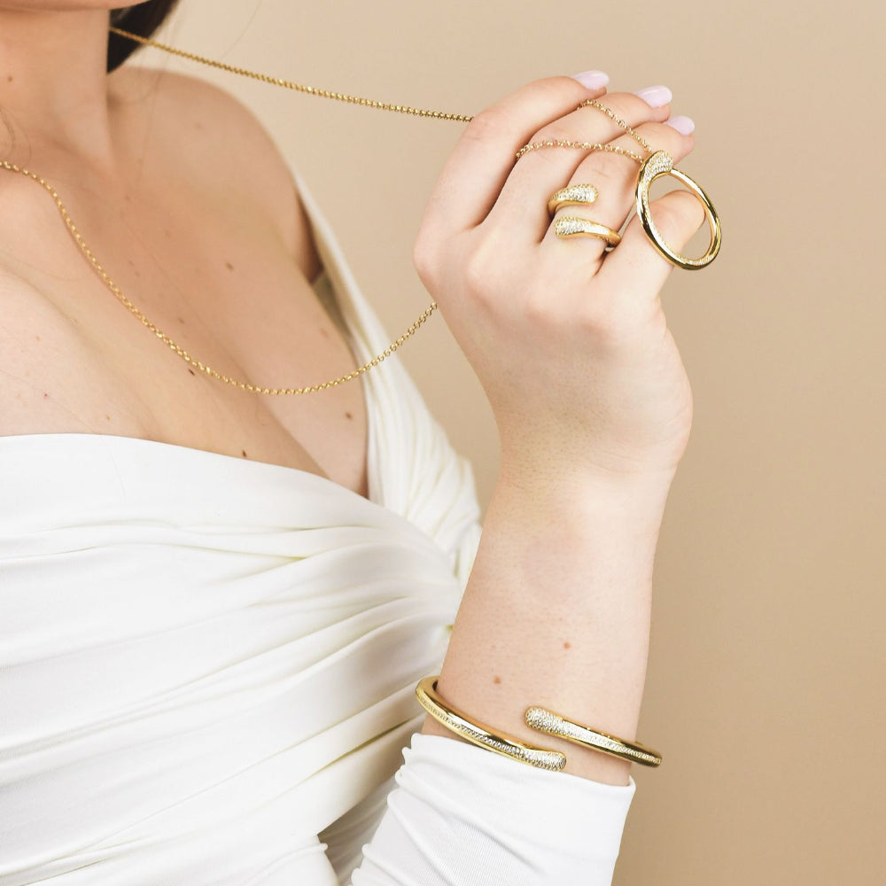 Elegant gold plated bronze wrap cuff bracelet adorned with sparkling pavé cubic zirconia stones for a timeless luxe look. Shop premium jewelry online.