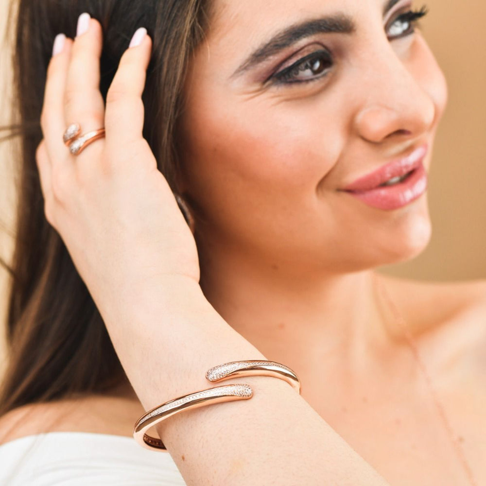 Elegant rose gold plated wrap cuff bracelet adorned with sparkling pavé cubic zirconia stones for a chic luxe statement. Shop premium jewelry online.