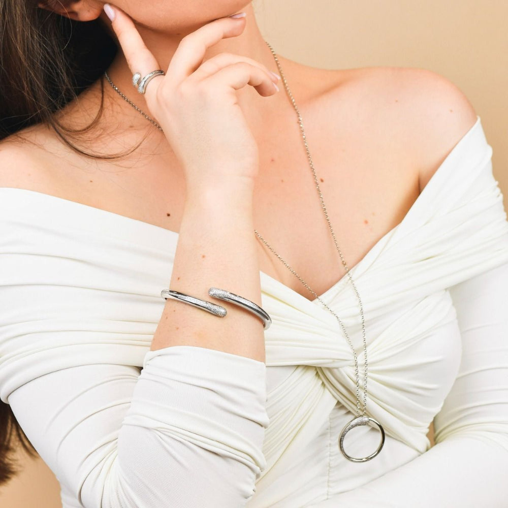 Elegant rhodium-plated bronze wrap cuff bracelet with sparkling pavé cubic zirconia stones for a modern luxe look. Shop premium jewelry online.