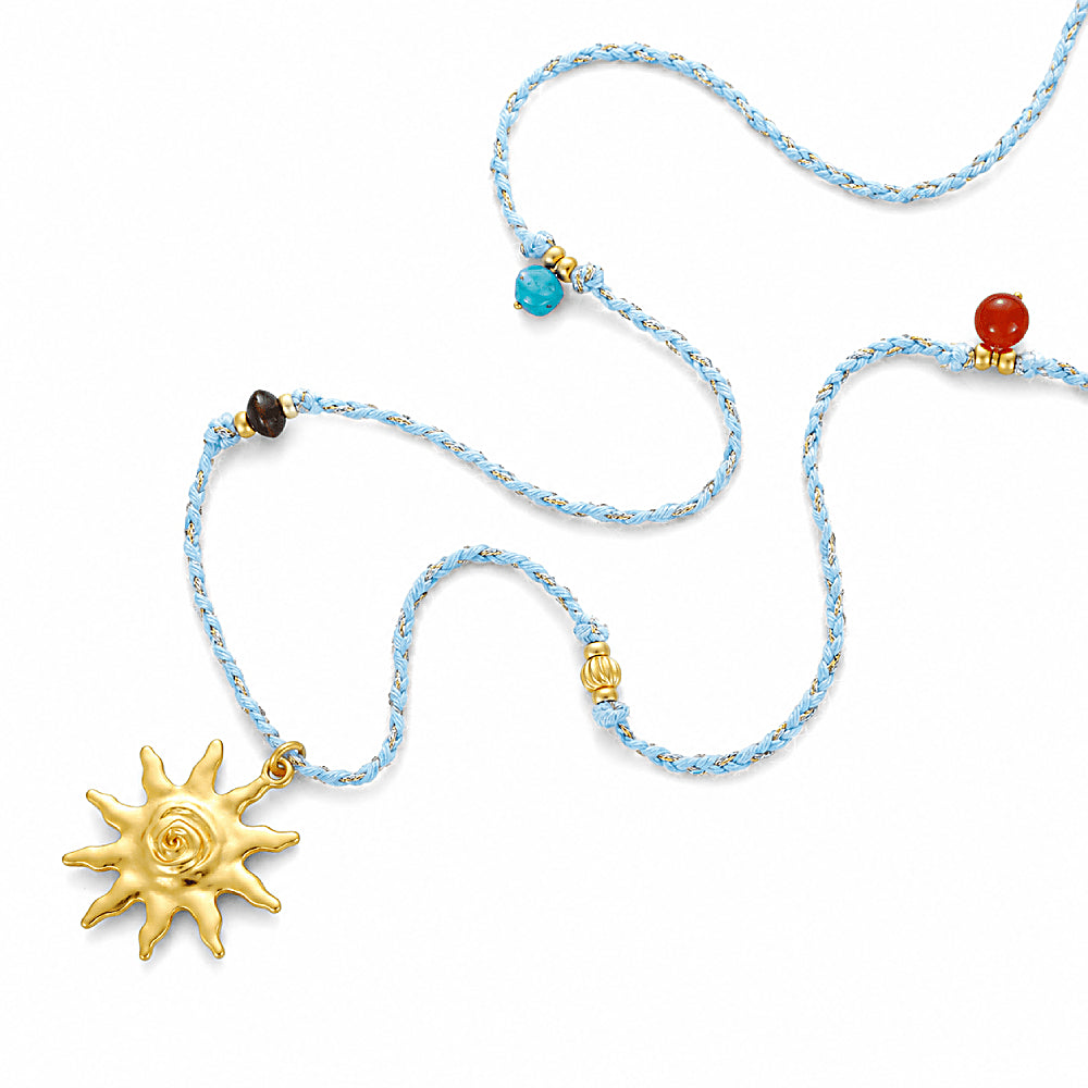 Discover the Solara Multi-Stone Cord Necklace at The Luxe Maison, featuring a radiant sun charm, vibrant natural stones, golden accents, and an adjustable sky-blue cord for a playful, sun-inspired look.