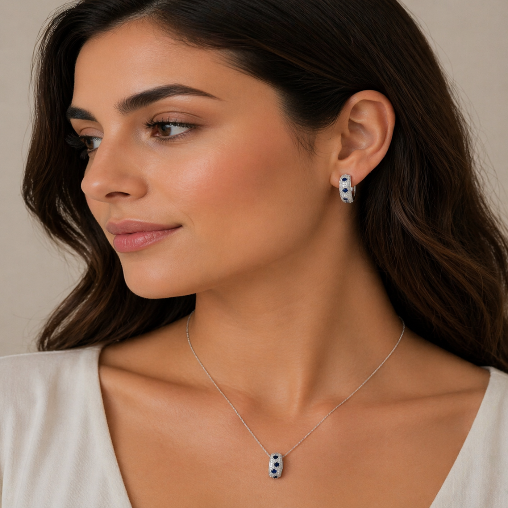Shop sterling silver blue sapphire huggie earrings featuring lab-created blue sapphire, sparkling cubic zirconia, and an elegant oval pavé design.