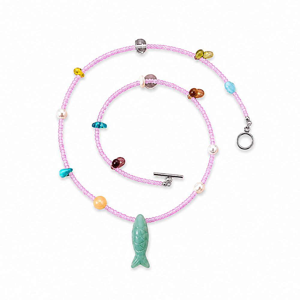Discover the Summertime Aventurine Fish Necklace at The Luxe Maison, featuring green aventurine, freshwater pearls, white crystal, and pastel beads for a playful, colorful summer look.