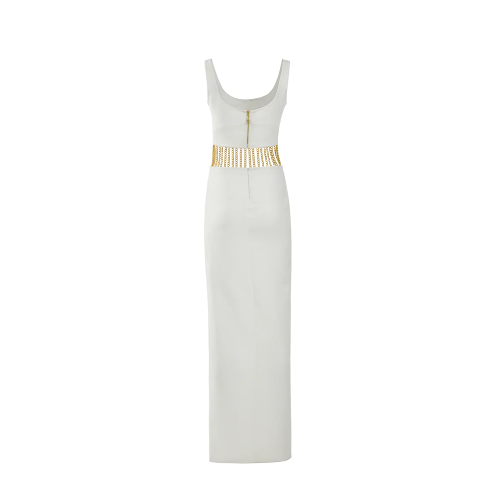 A white silk crepe dress with a thigh-high side slit and gold chain detailing at the waistline.