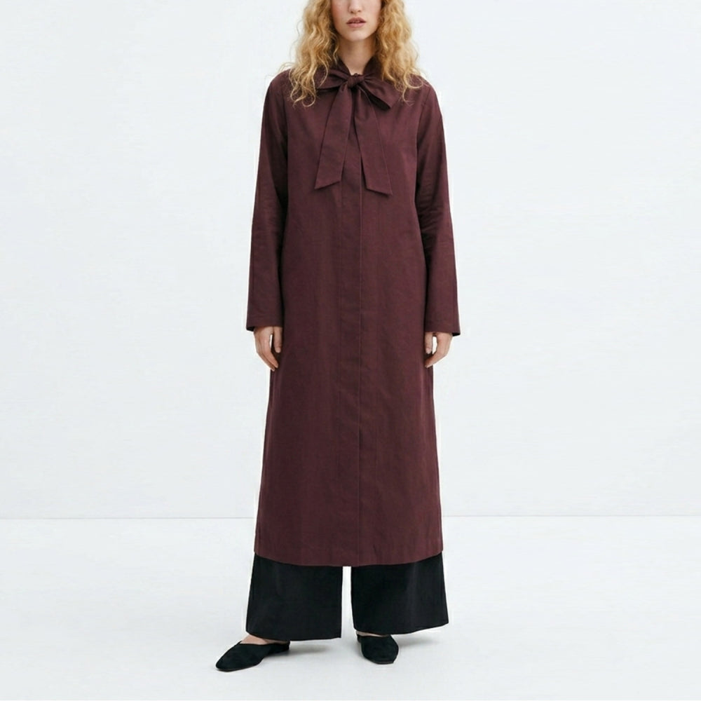 Discover the Zen Coat at The Luxe Maison, featuring a lightweight, unlined design, stand-up collar, tie fastening, bell sleeves, and a slim calf-length silhouette.