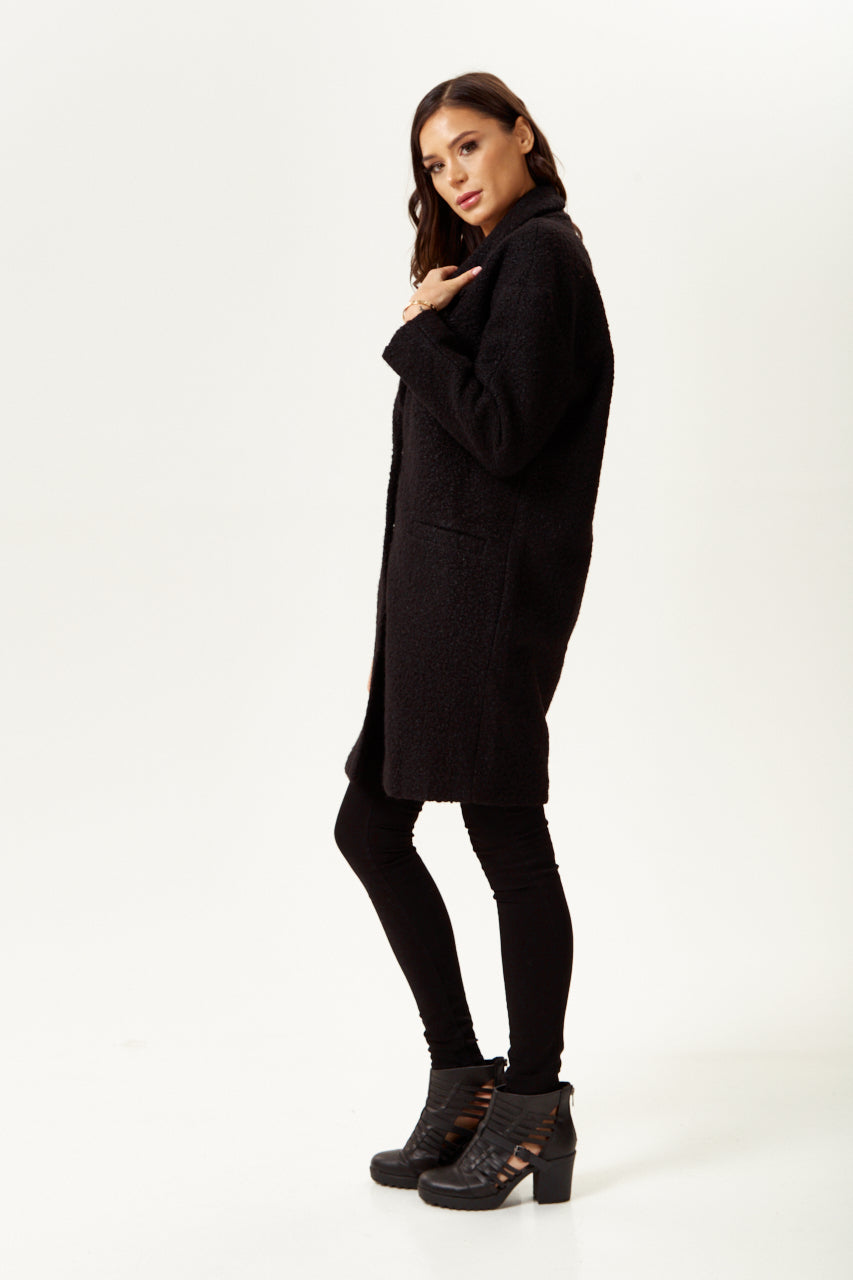 Clothing shop online offering a women’s extra loose fit black bouclé coat for chic layering. Shop Now!