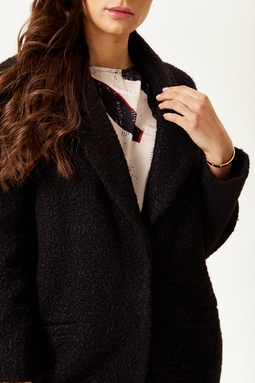 Clothing shop online offering a women’s extra loose fit black bouclé coat for chic layering. Shop Now!