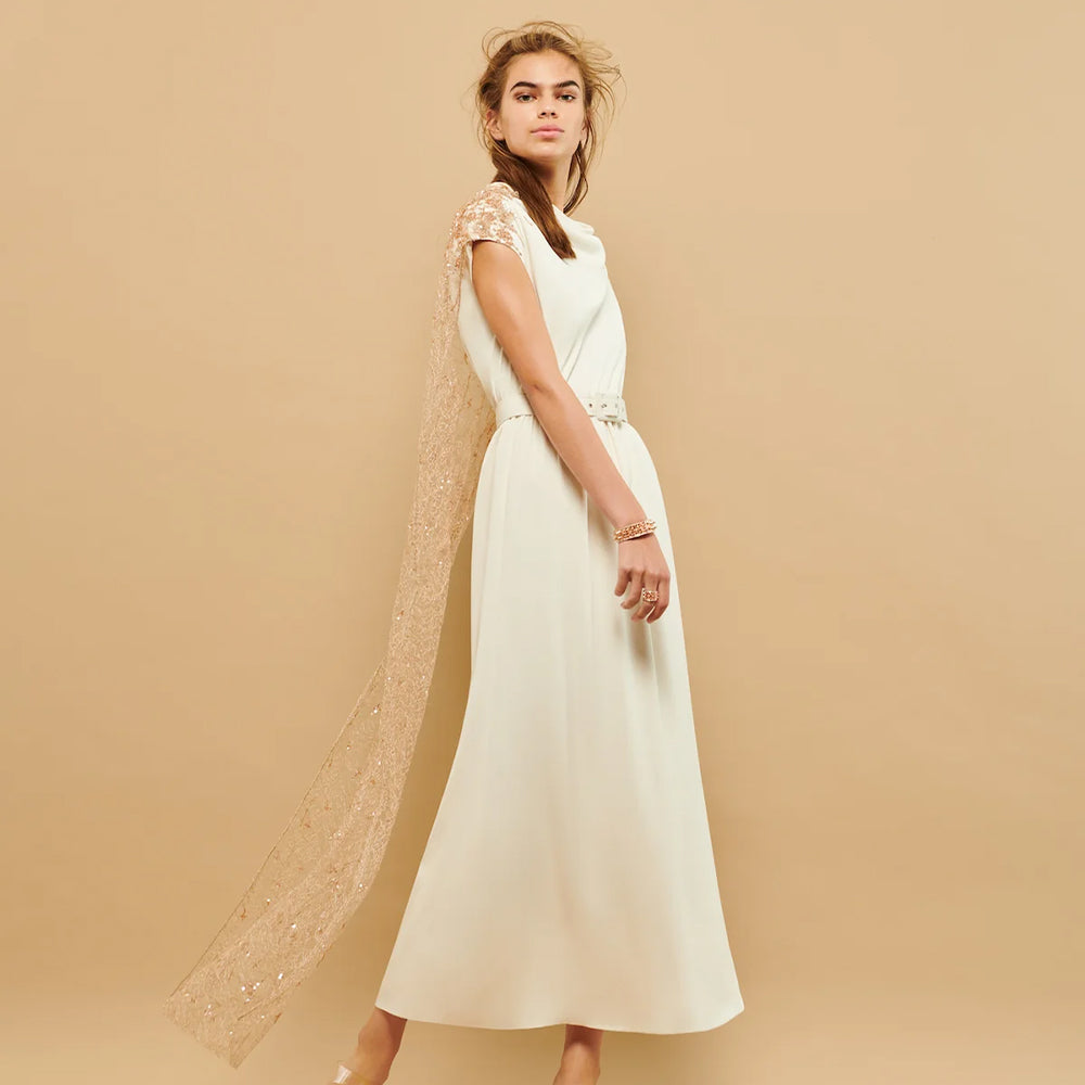 This cowl neck dress features an embroidered tulle cape and a coordinating belt, creating a stylish and elegant.