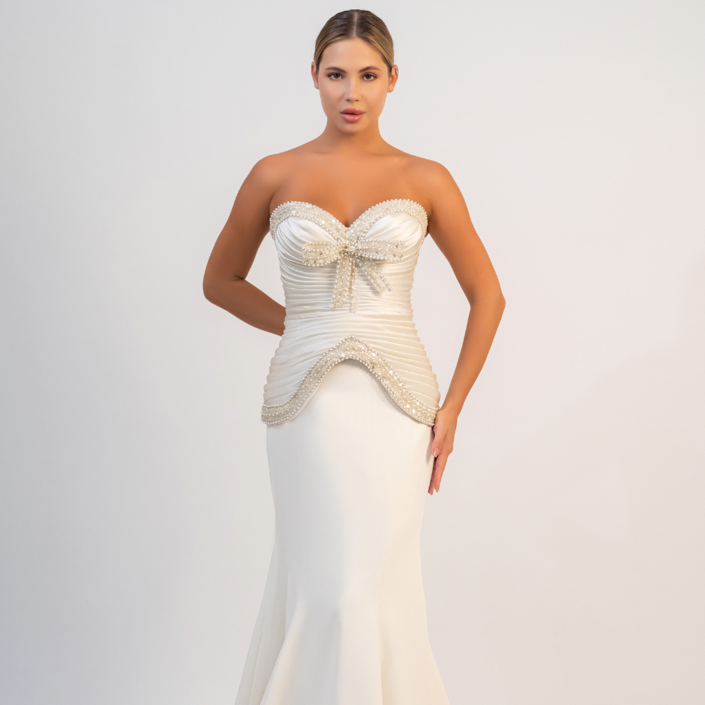 Shop online elegant off-white gown with sculpted bodice, sparkling details and graceful mermaid silhouette, perfect for weddings, parties and special occasions.