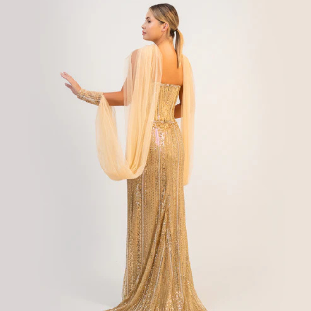 Shop online dazzling gold gown with sparkling corset, sleek silhouette and flowing cape-inspired details, perfect for parties and special occasions.