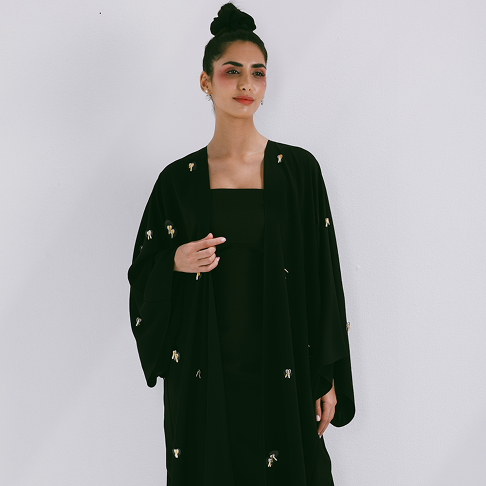 Classic abaya with scattered embroidery in crepe fabric. Comes with sheila. Explore our range of designer abayas online at The Luxe Maison. Shop now!