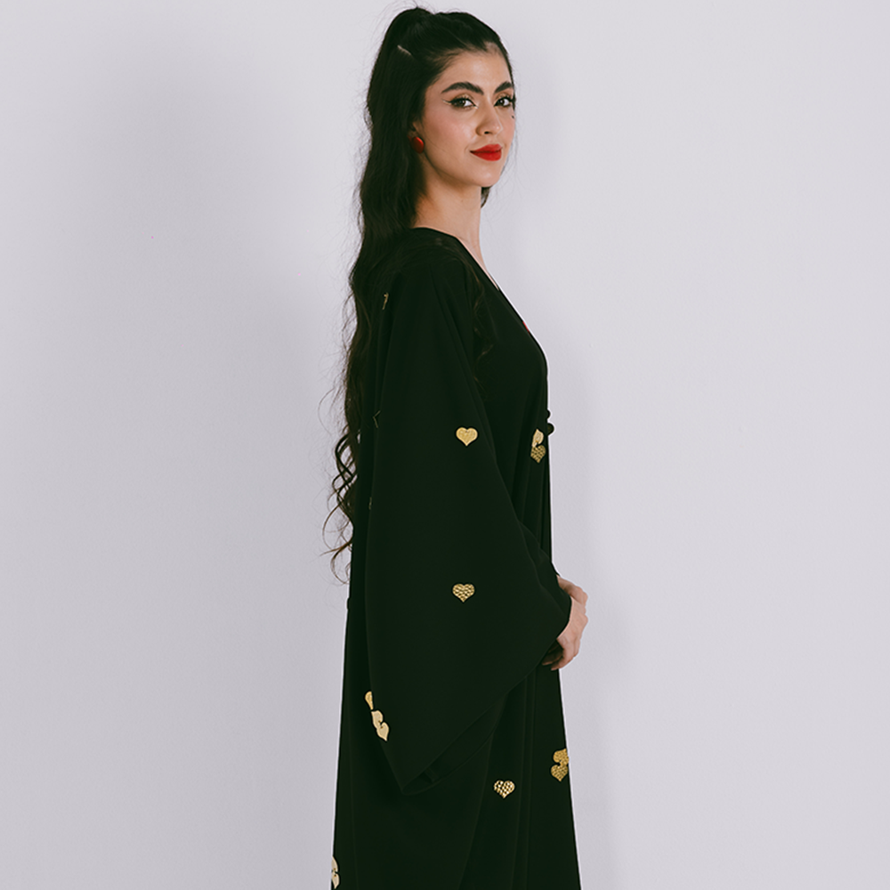 Classic abaya with metal heart motifs in crepe fabric. Comes with sheila. Shop from our range of designer abaya online at The Luxe Maison. Shop now!