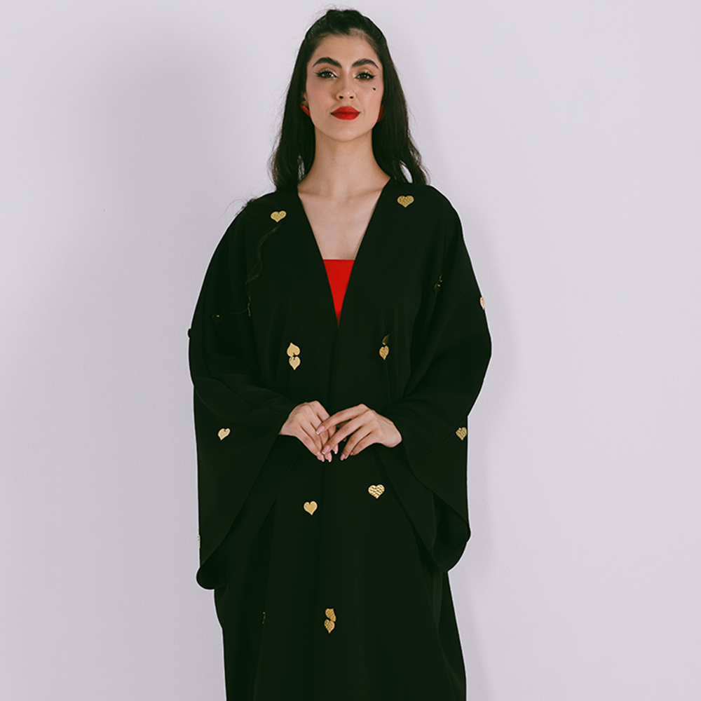 Classic abaya with metal heart motifs in crepe fabric. Comes with sheila. Shop from our range of designer abaya online at The Luxe Maison. Shop now!