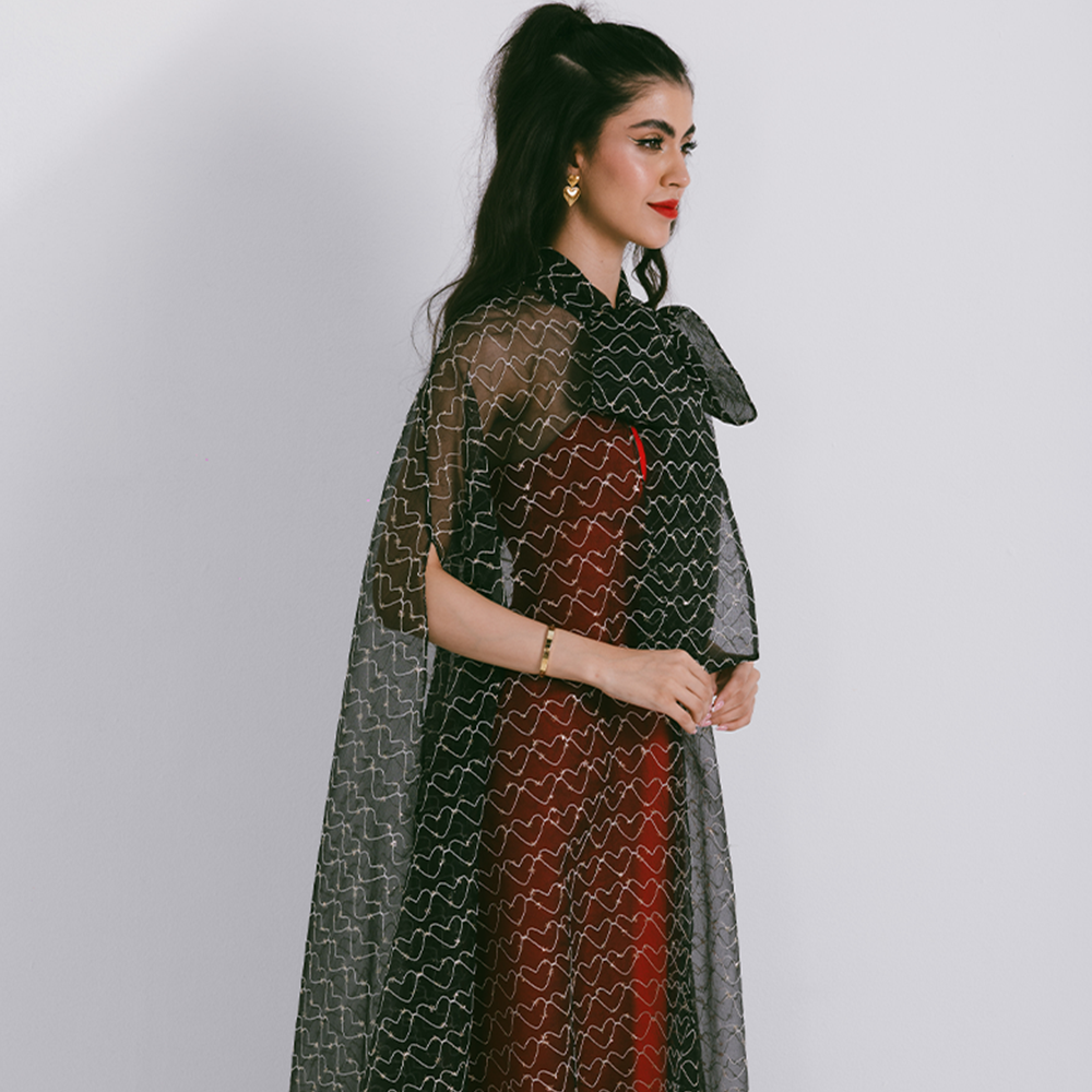 Organza cape with neck bow & heart shaped metallic threads on transparent fabric. Dress sold separately. Explore stylish capes for women. Shop now!