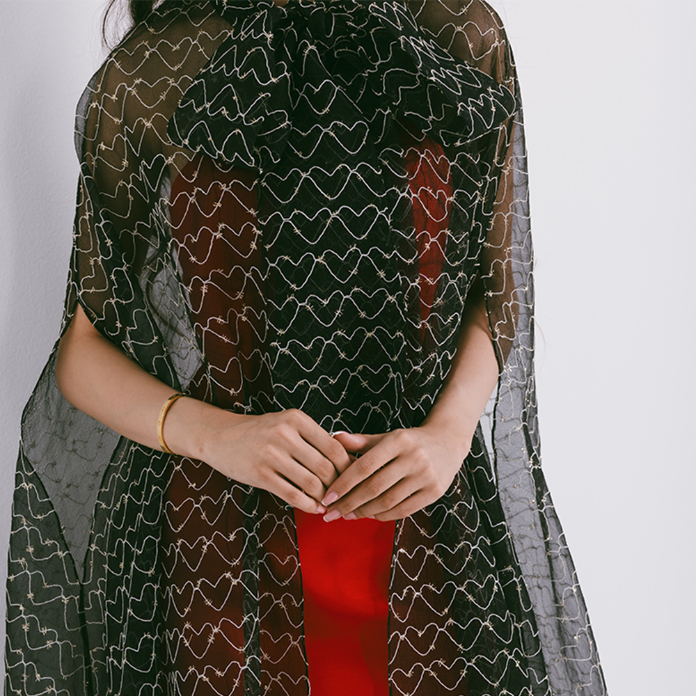 Organza cape with neck bow & heart shaped metallic threads on transparent fabric. Dress sold separately. Explore stylish capes for women. Shop now!