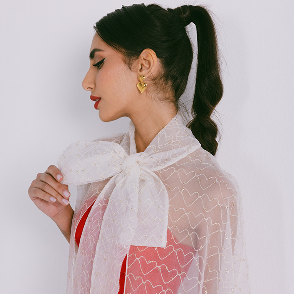 Organza cape with neck bow & heart shaped metallic threads on transparent fabric. Dress sold separately. Explore stylish capes for women. Shop now!