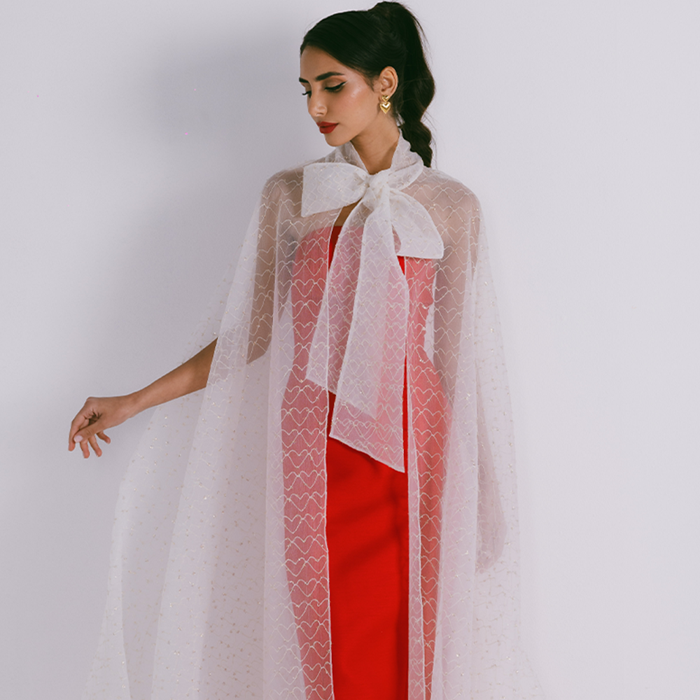 Organza cape with neck bow & heart shaped metallic threads on transparent fabric. Dress sold separately. Explore stylish capes for women. Shop now!