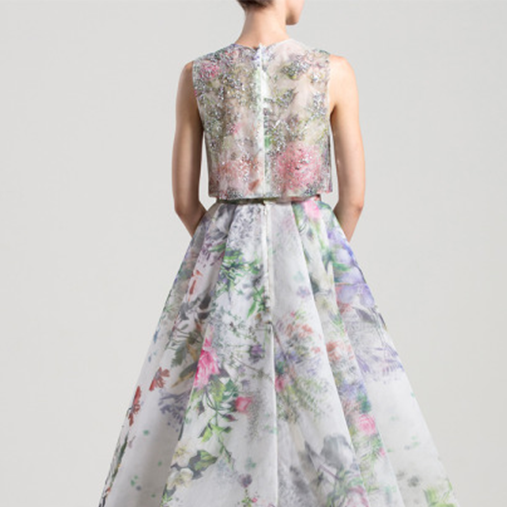 Loose, sleeveless embroidered shirt with a round neckline; high waist printed organza skirt with a slit and an overskirt. 