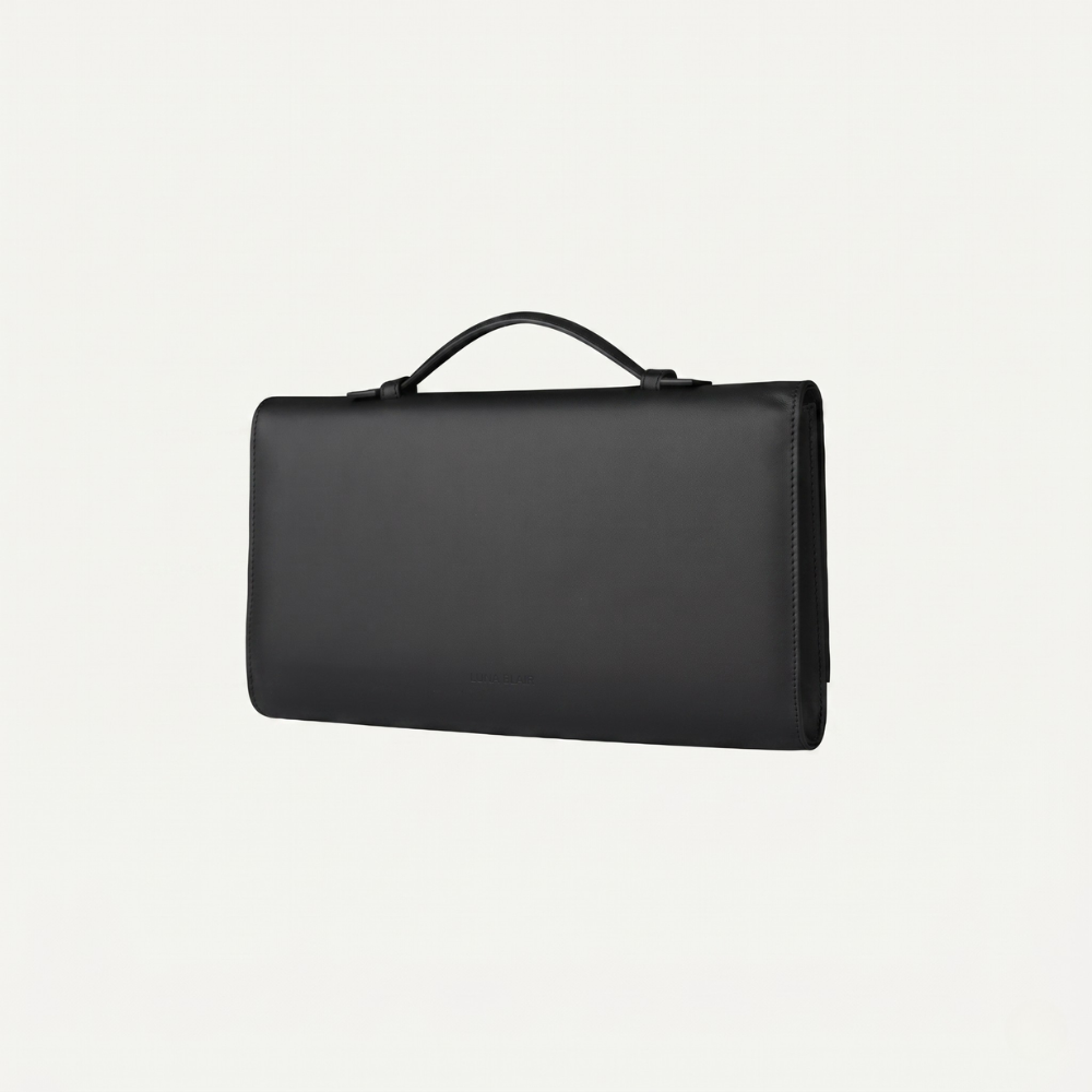 Italian leather clutch with strap and silver hardware, perfect for events. Shop online from our curated edit of premium fashion.