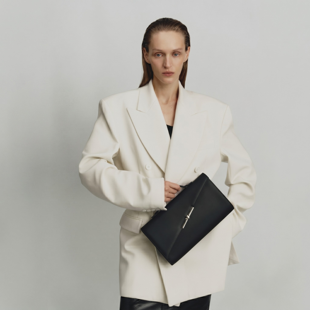 Italian leather clutch with strap and silver hardware, perfect for events. Shop online from our curated edit of premium fashion.