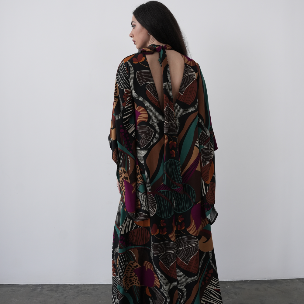 A-line maxi dress with long flared sleeves and a halterneck with attached scarf, with a deep V back cut.