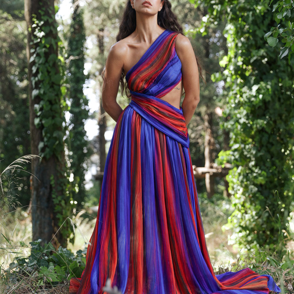 Long asymmetric pliss, dress, with cut-out detail. The exclusive printed scene on chiffon fabric.