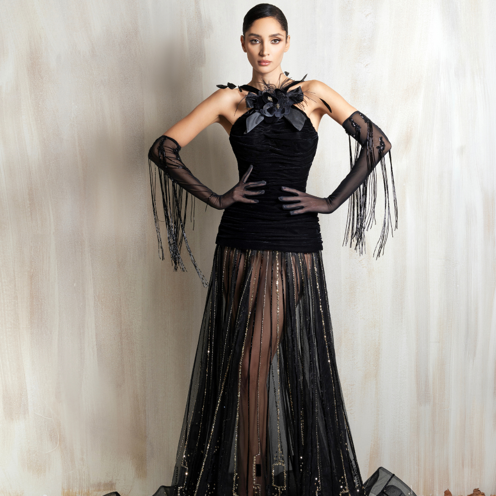 Black halter gown with a floral neckline and sheer embellished skirt, crafted for elegant occasions. Shop now at our exclusive clothing website.