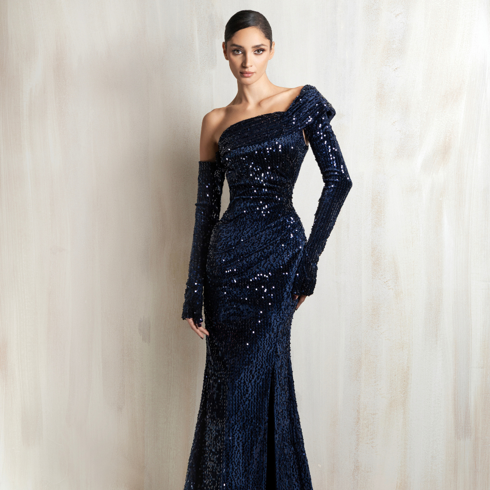 Navy sequined off-shoulder mermaid gown with glove sleeves, crafted for glamorous evening occasions. Shop now at our exclusive clothing website.