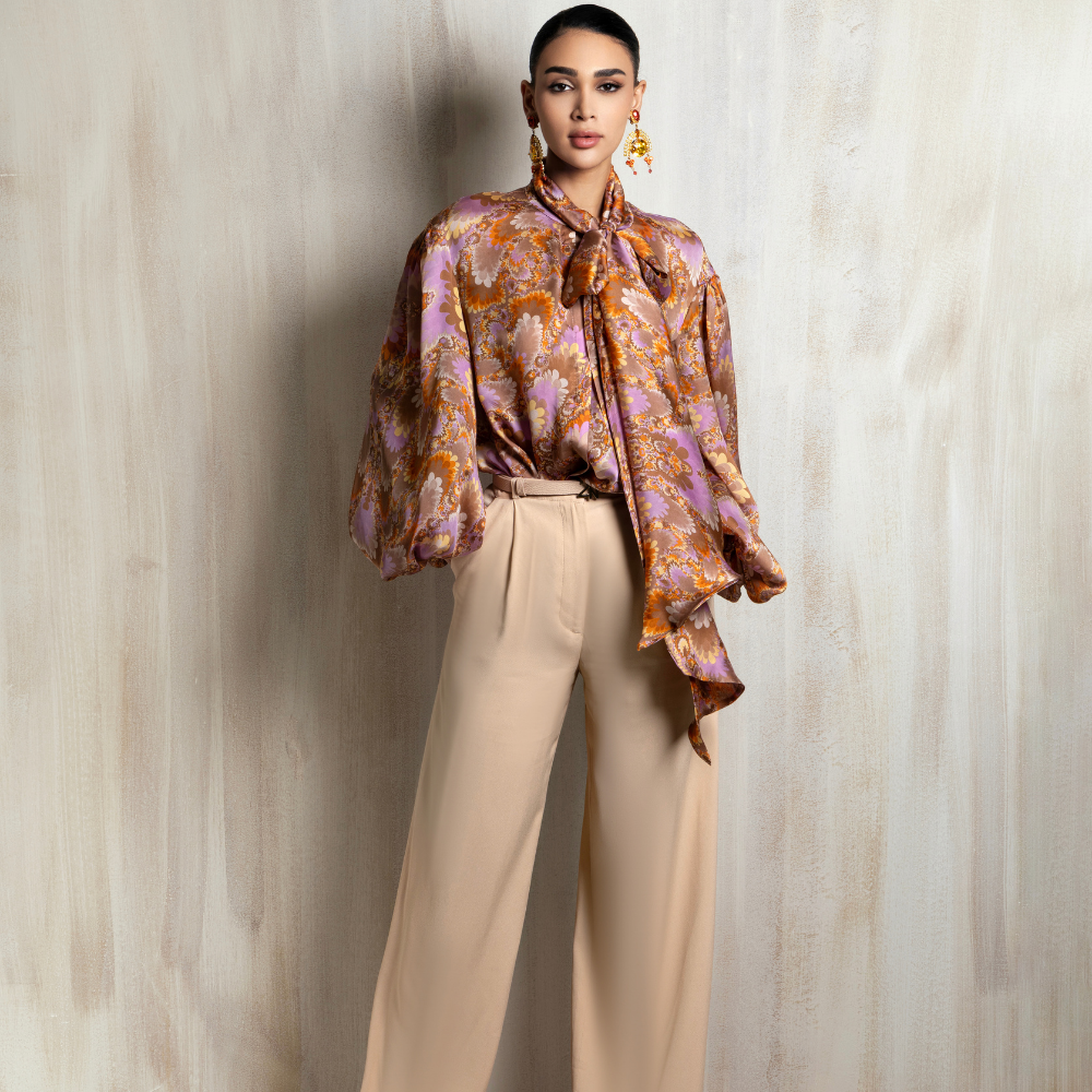 Printed silk blouse paired with relaxed beige wide-leg trousers, designed for effortless sophistication. Shop now at our exclusive clothing website.