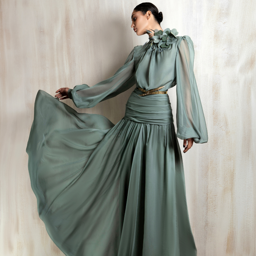 Flowing sage green chiffon gown with floral neckline detail, designed for soft elegance. Shop now at our exclusive clothing website.