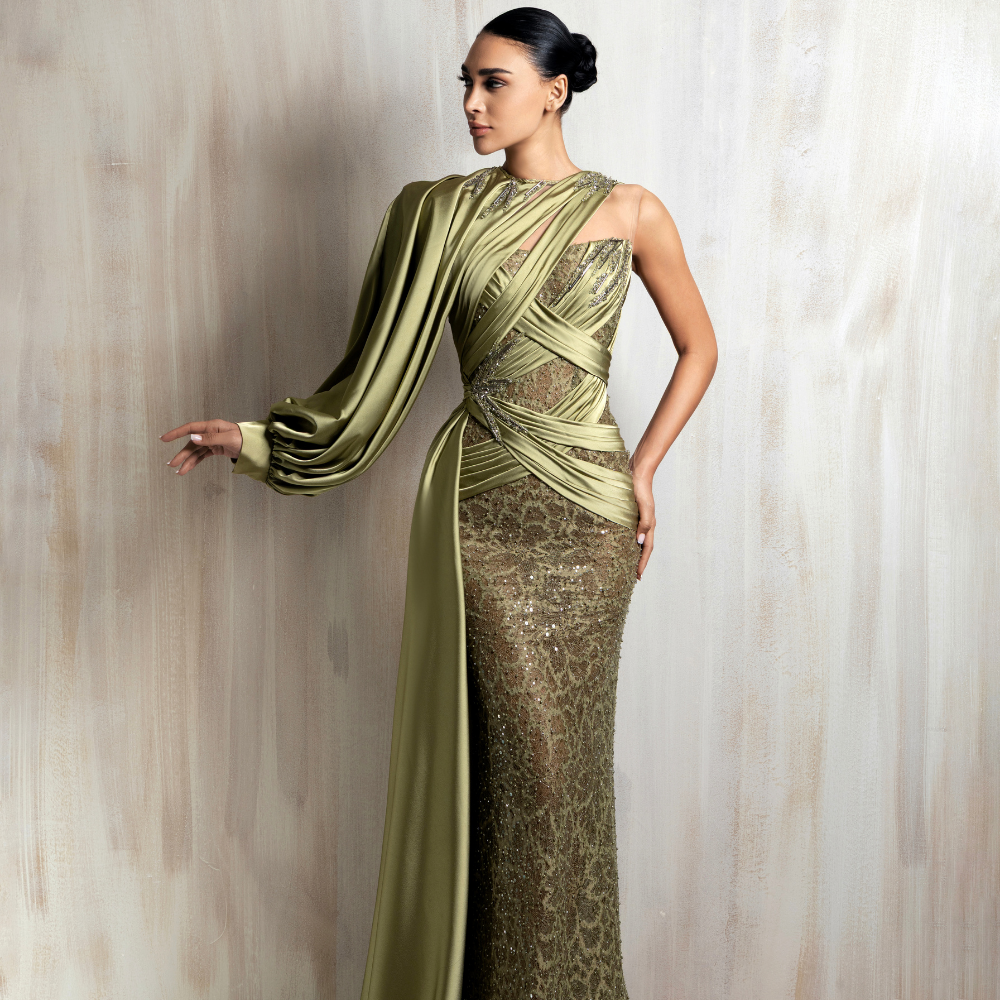 Asymmetric olive green gown with a one-shoulder draped sleeve, satin crisscross detailing, and a flowing side panel. Shop now at our exclusive clothing website.