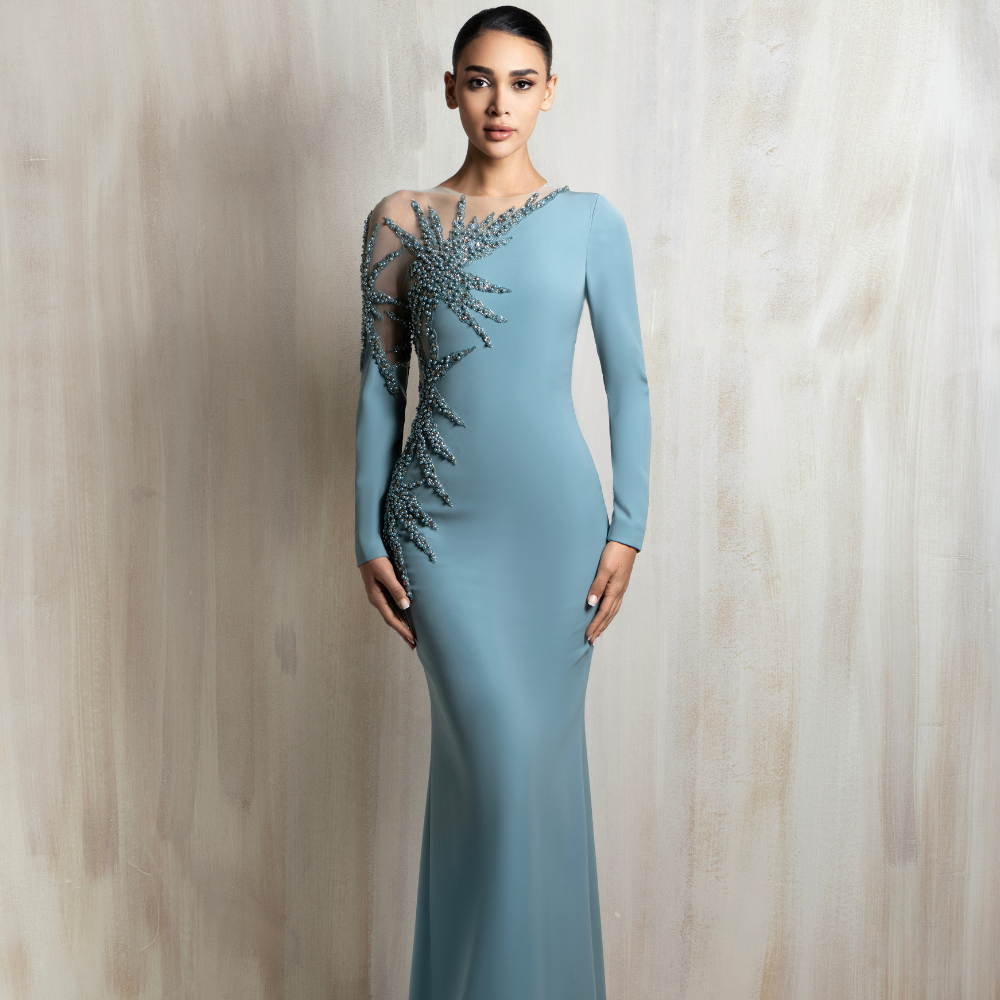 Long-sleeve icy blue gown with a fitted silhouette and crystal-embellished asymmetrical shoulder panel. Shop now at our exclusive clothing website.