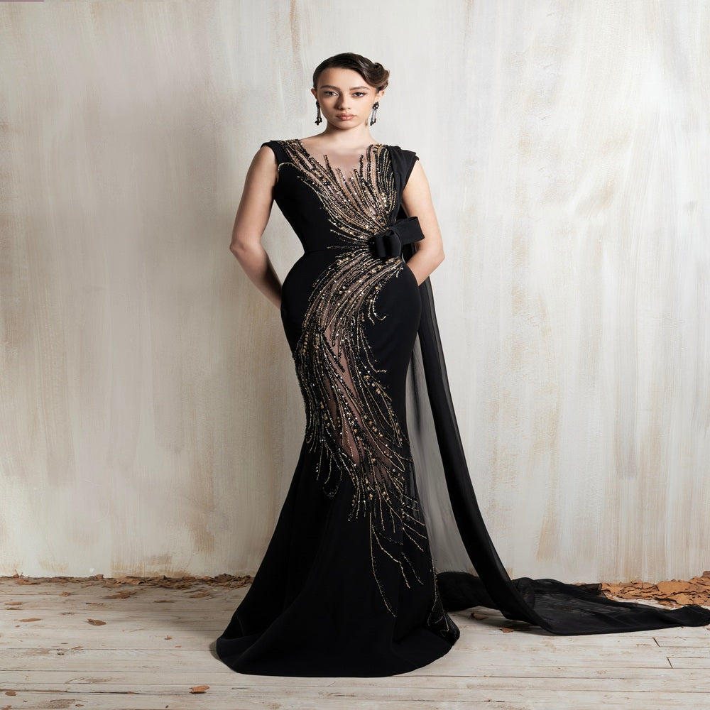 Black gown with golden cascade embroidery and a sleek flowing cape, crafted for glamorous evening events and special occasions. Shop now at our exclusive clothing website.
