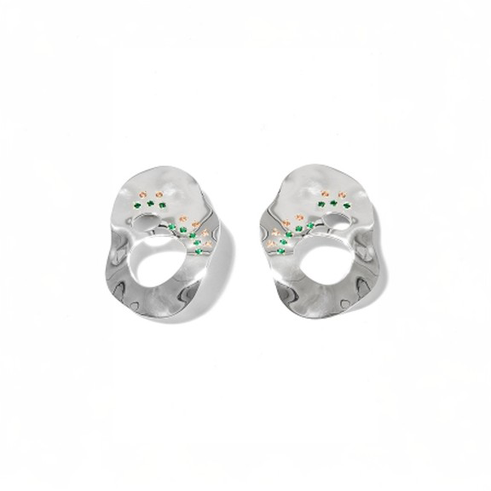 Statement earrings embellished with multi colored zircon stones on reflective surface.