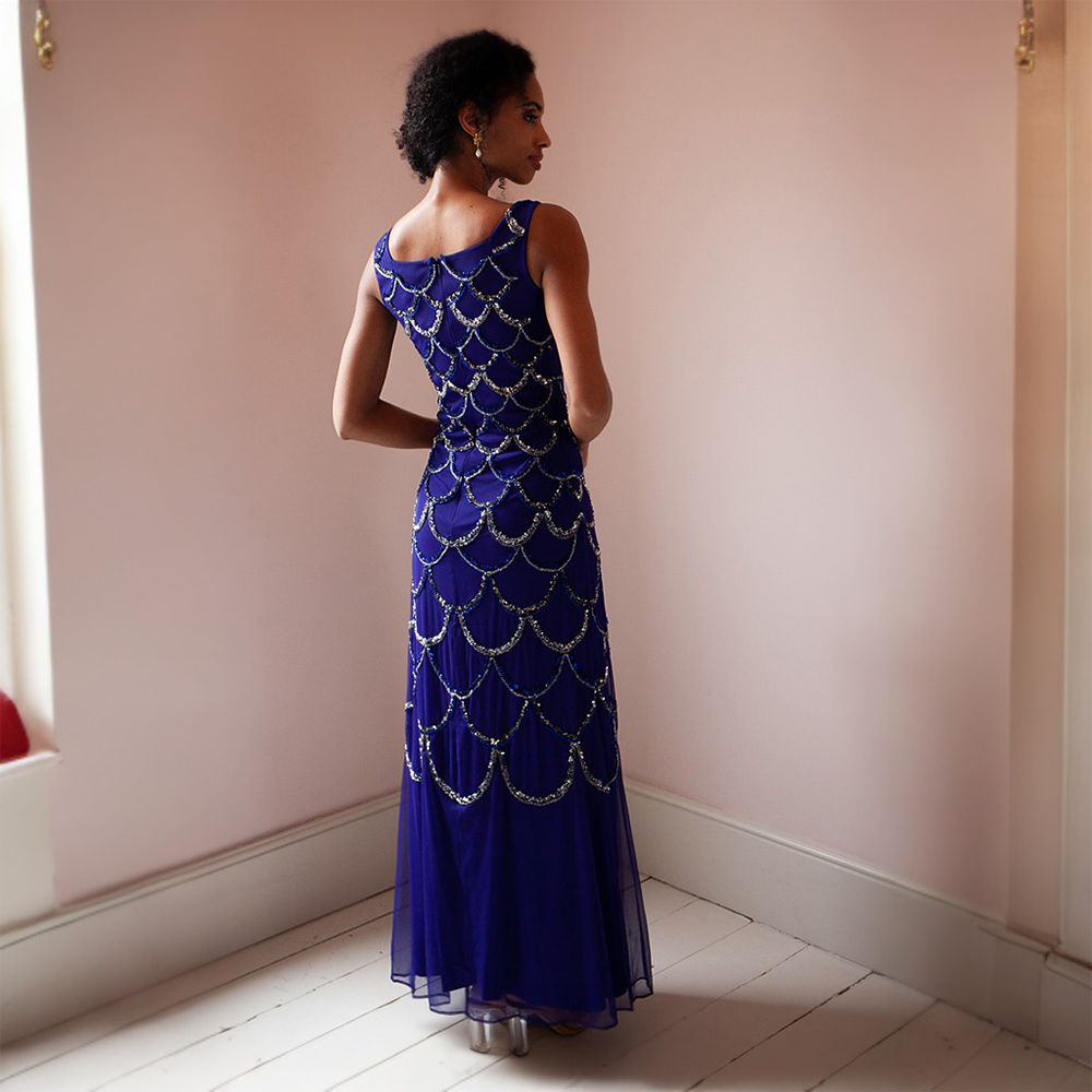 This glamorous blue floor-length gown features gold and silver sequins as well as a cape that can be taken on or off 