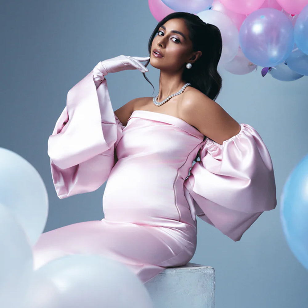 Blush pink satin maternity dress with off shoulder sleeves and A-line fit, perfect for baby showers. Shop online from our curated edit of premium fashion.