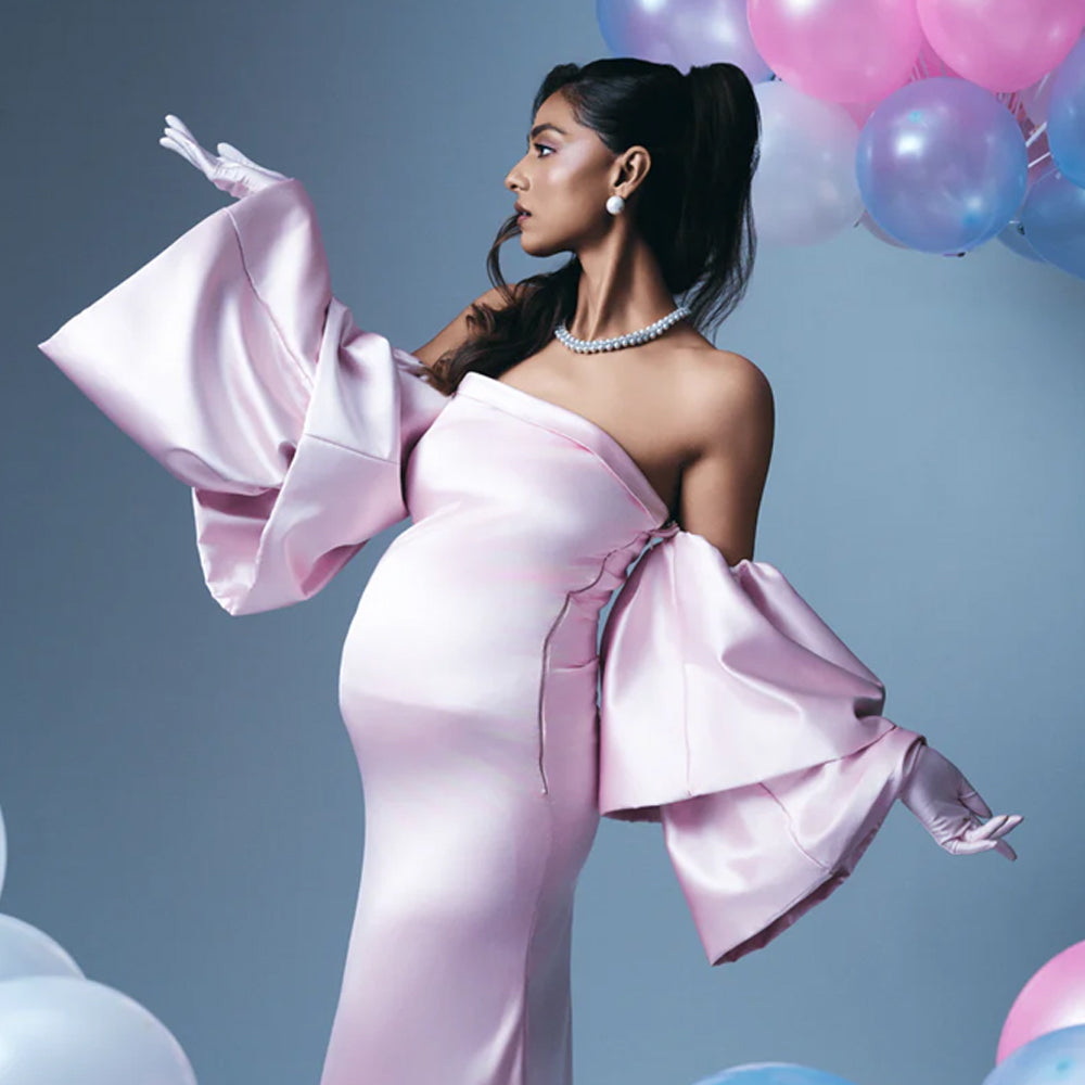 Blush pink satin maternity dress with off shoulder sleeves and A-line fit, perfect for baby showers. Shop online from our curated edit of premium fashion.