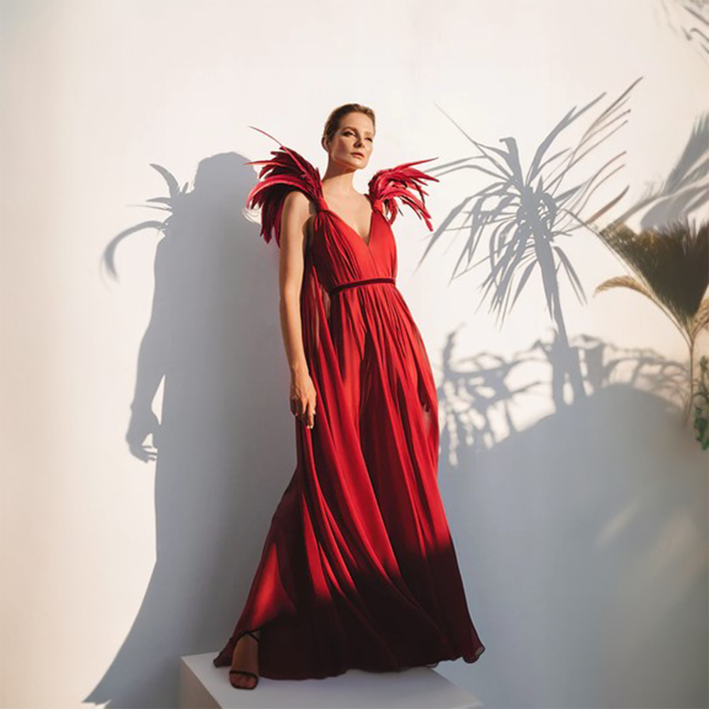 A deep saturated burgundy silk chiffon dress with a plunging neckline and feathered shoulders.