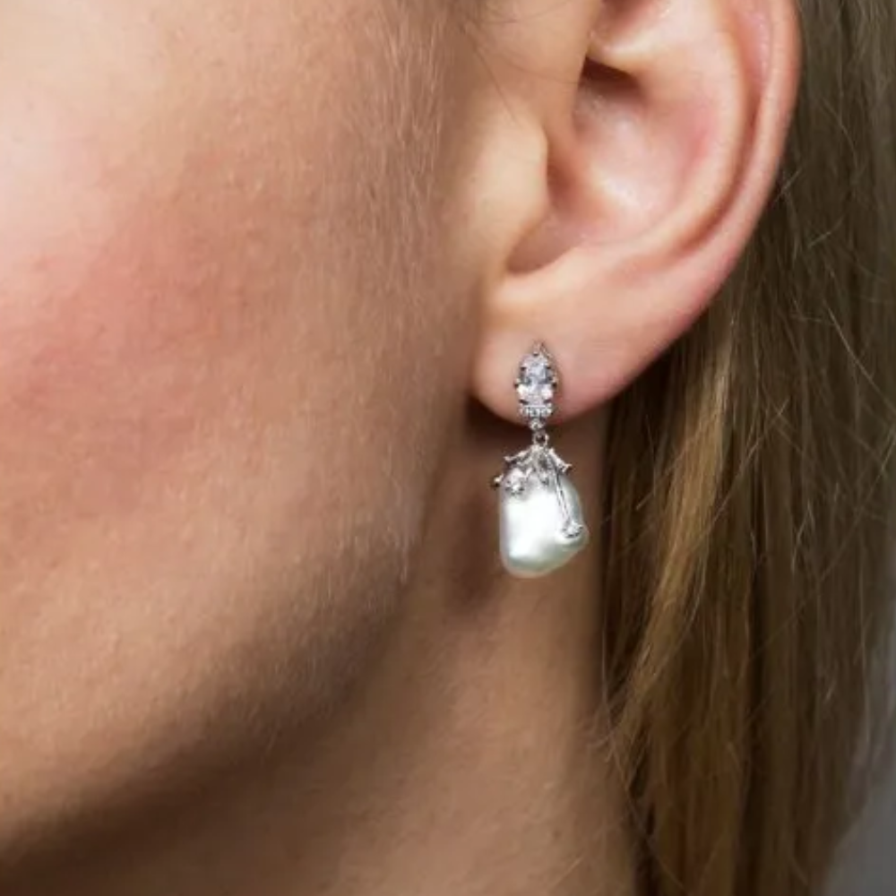 6 CTTW Pear and round cubic zirconia with freshwater pearl drop. Post earring set in rhodium-plated brass.