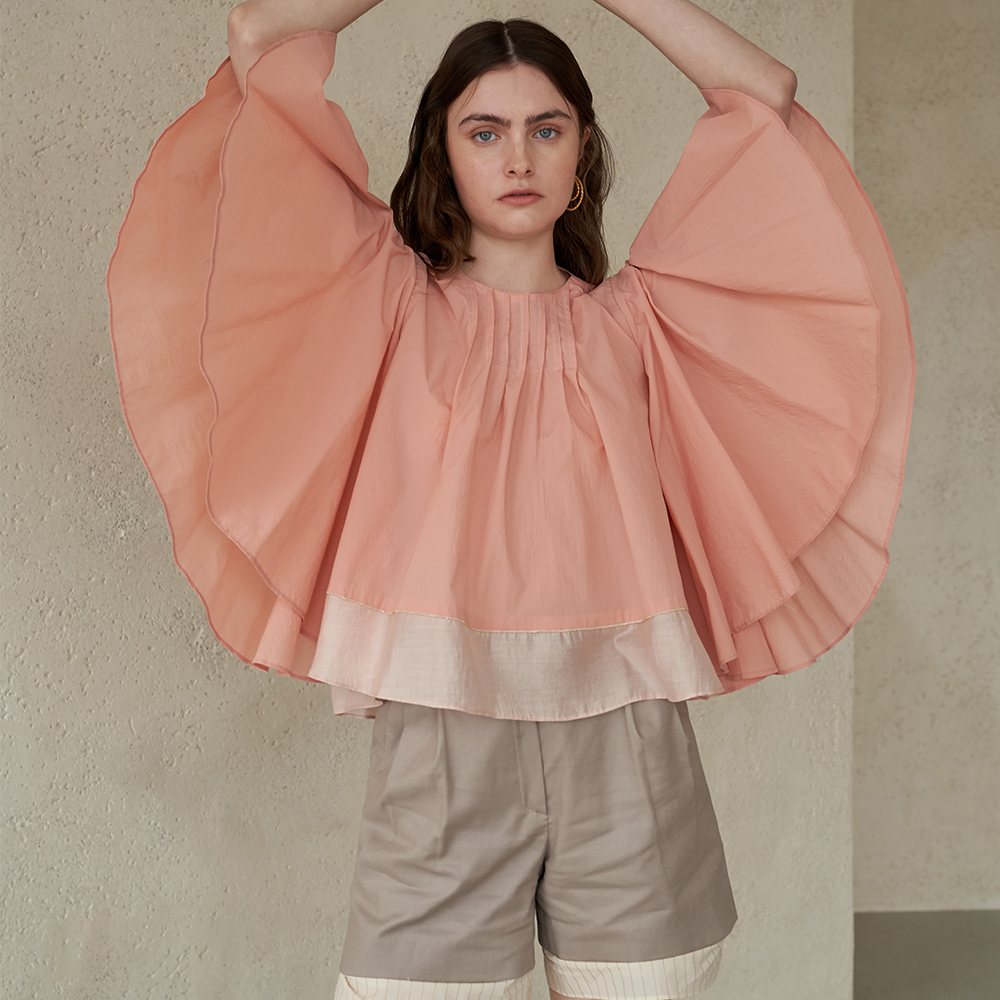 Light apricot colored winged blouse